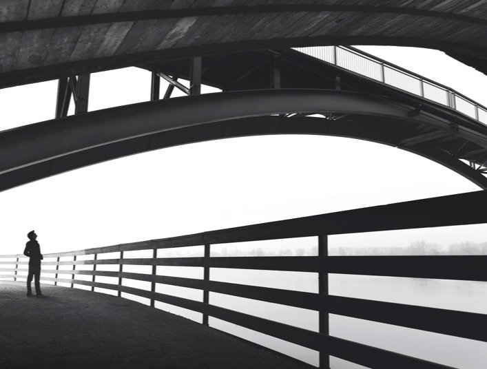 small business owner standing under bridge black and white